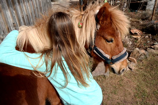 Osterzeit: Mädchen umarmt Pony